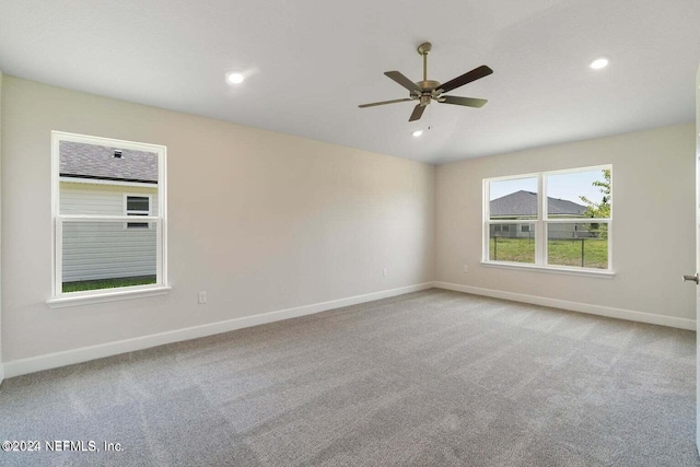 empty room featuring ceiling fan and light colored carpet