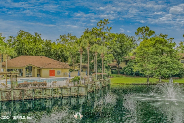 exterior space featuring a swimming pool, a yard, and a water view