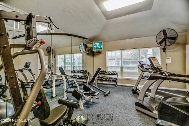 gym featuring lofted ceiling, a textured ceiling, and plenty of natural light