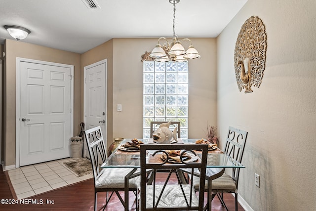 dining area with light hardwood / wood-style flooring and a notable chandelier