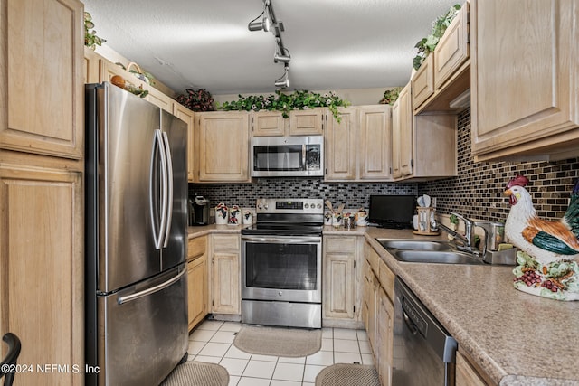 kitchen with tasteful backsplash, light brown cabinetry, sink, light tile patterned flooring, and stainless steel appliances