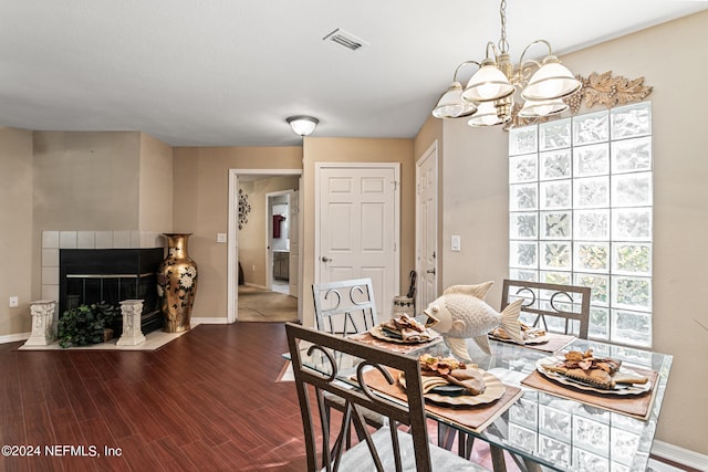 dining space featuring an inviting chandelier, hardwood / wood-style floors, and a fireplace