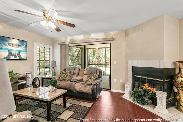 living room with hardwood / wood-style floors, a fireplace, a textured ceiling, and ceiling fan