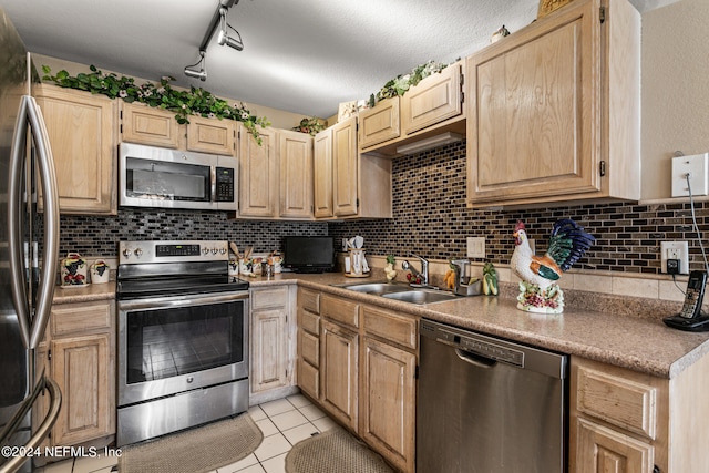 kitchen featuring appliances with stainless steel finishes, light brown cabinets, tasteful backsplash, and sink