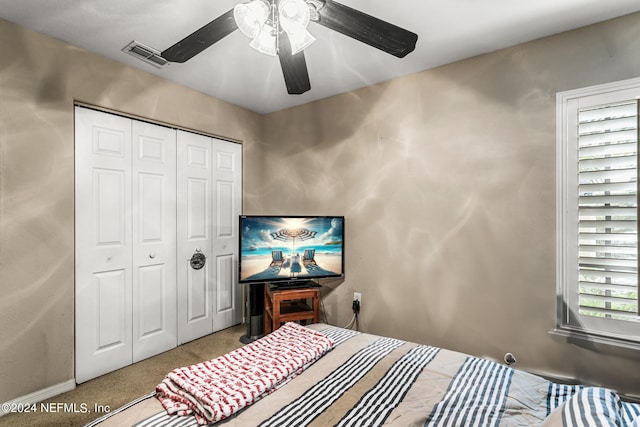 carpeted bedroom featuring a closet and ceiling fan