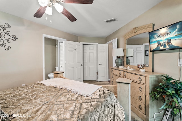 bedroom featuring connected bathroom, ceiling fan, light carpet, and a closet