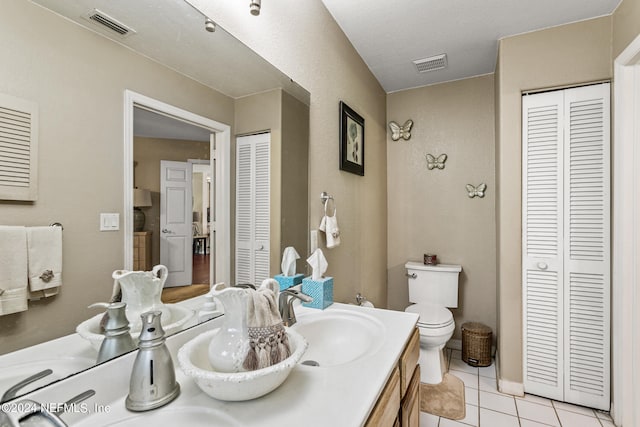 bathroom featuring vanity, toilet, and tile patterned floors