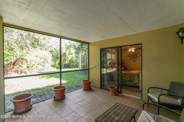 unfurnished sunroom with ceiling fan