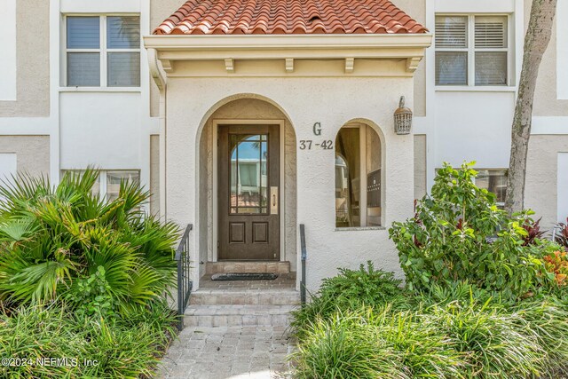 10 10th St Unit 37, Atlantic Beach, FL 32233 - doorway to property with stucco siding and a tile roof