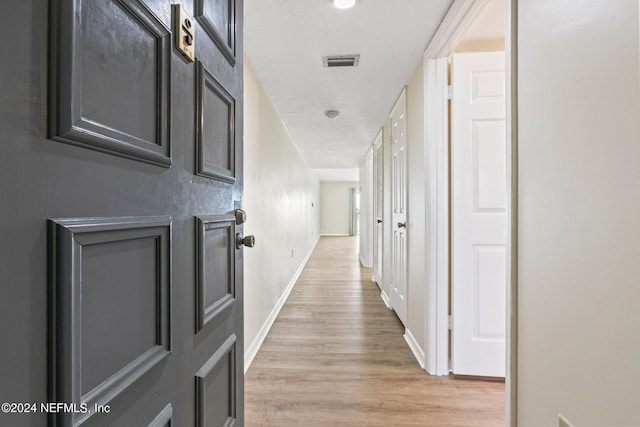 corridor with light hardwood / wood-style floors