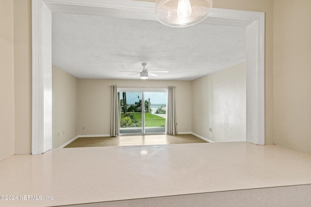 empty room featuring ceiling fan and a textured ceiling