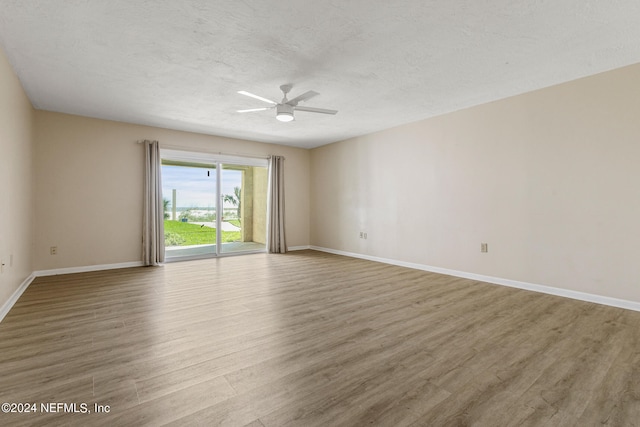 unfurnished room with ceiling fan, light hardwood / wood-style flooring, and a textured ceiling