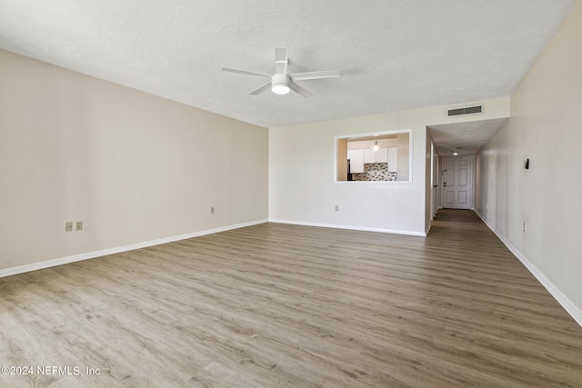 unfurnished living room with ceiling fan, wood-type flooring, and a textured ceiling