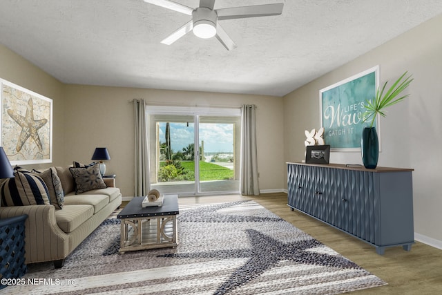 living room with hardwood / wood-style floors, a textured ceiling, and ceiling fan