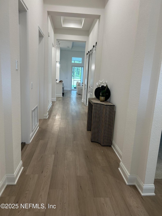 49 Pathway Ct, Saint Johns, FL 32259 - hallway with a barn door, wood finished floors, and baseboards