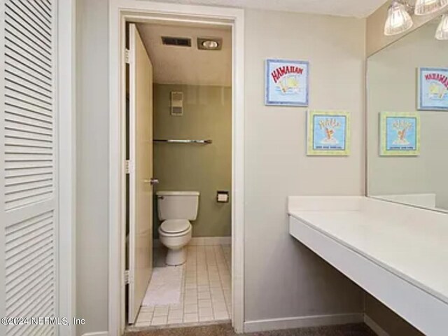 bathroom with tile patterned flooring, vanity, and toilet