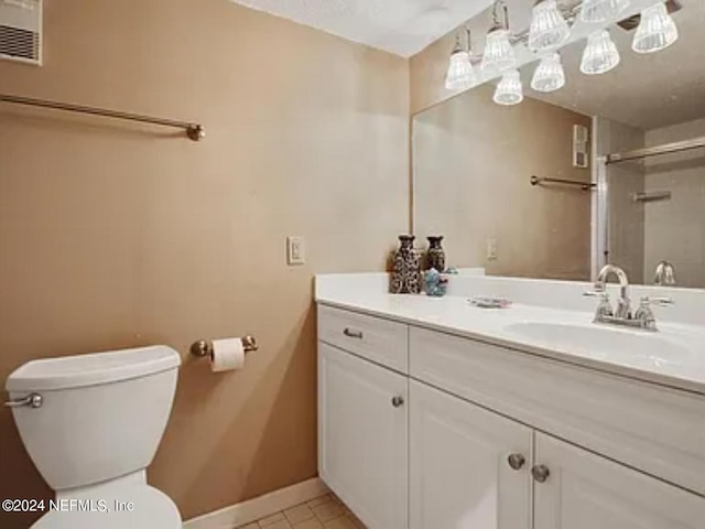 bathroom with vanity, tile patterned flooring, toilet, and an enclosed shower