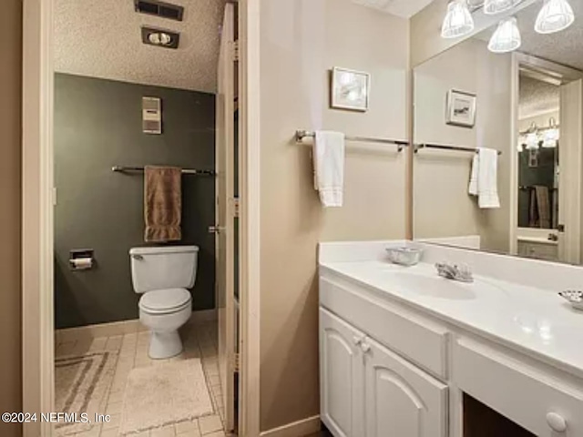 bathroom with tile patterned flooring, vanity, and toilet