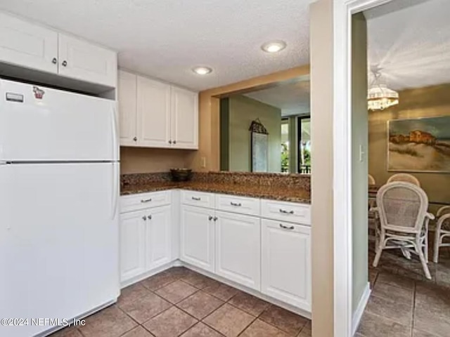 kitchen featuring light tile patterned floors, white cabinets, and white fridge