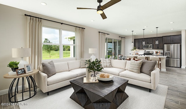 living room with light hardwood / wood-style floors and ceiling fan