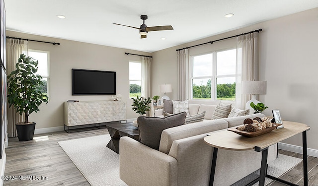 living room featuring light wood-type flooring and ceiling fan