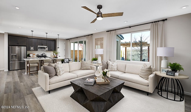 living room with ceiling fan, dark hardwood / wood-style floors, and a healthy amount of sunlight