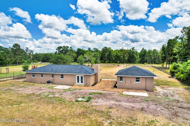 back of house with a rural view and central AC