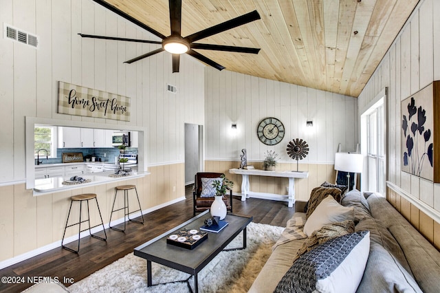 living room with wood ceiling, dark hardwood / wood-style floors, wood walls, and high vaulted ceiling