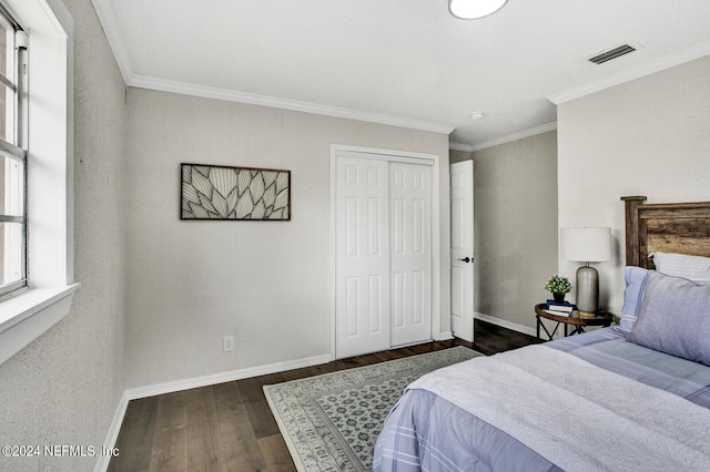 bedroom with a closet, dark wood-type flooring, and crown molding