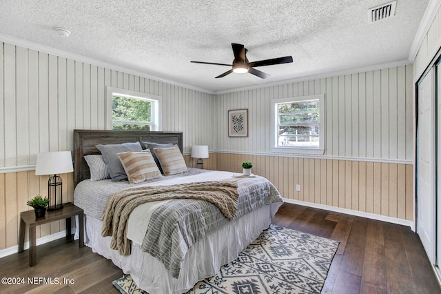 bedroom featuring multiple windows, dark hardwood / wood-style flooring, and ceiling fan