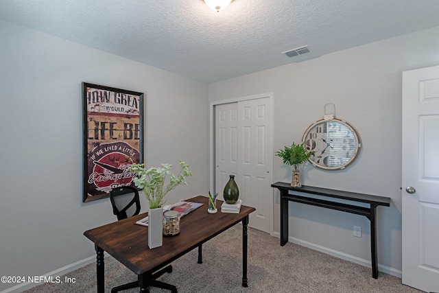 carpeted home office with a textured ceiling