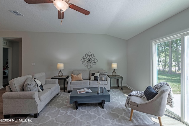 living room with wood-type flooring, vaulted ceiling, and ceiling fan