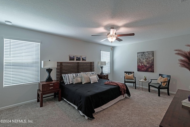 bedroom featuring ceiling fan, a textured ceiling, carpet flooring, and multiple windows