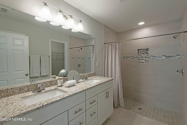 bathroom with a textured ceiling, tile patterned flooring, vanity, and a shower with shower curtain