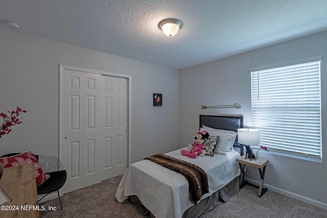 carpeted bedroom featuring a closet and a textured ceiling