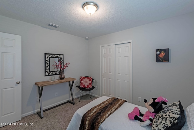 bedroom with carpet, a closet, and a textured ceiling