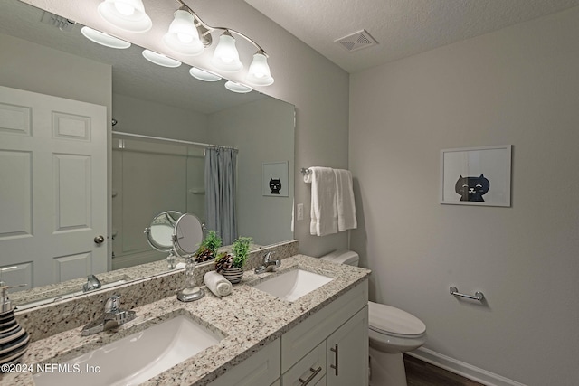 bathroom featuring a textured ceiling, hardwood / wood-style flooring, a shower with curtain, vanity, and toilet