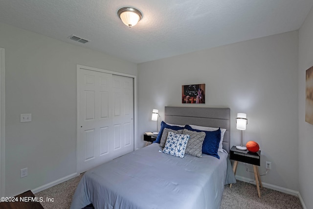 carpeted bedroom with a closet and a textured ceiling