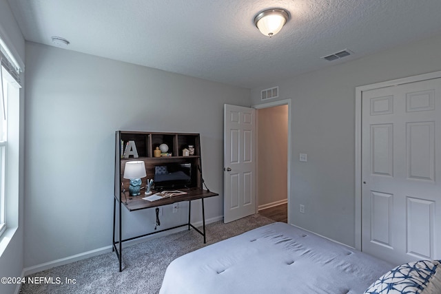 carpeted bedroom with a textured ceiling