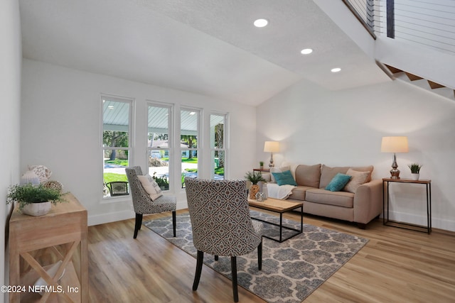 living room featuring light hardwood / wood-style floors and vaulted ceiling