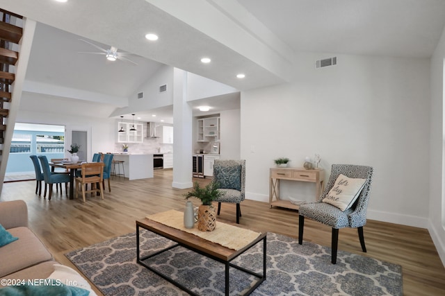 living room featuring high vaulted ceiling, light hardwood / wood-style flooring, ceiling fan, and wine cooler