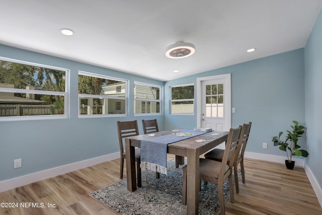 dining space featuring lofted ceiling and light hardwood / wood-style flooring