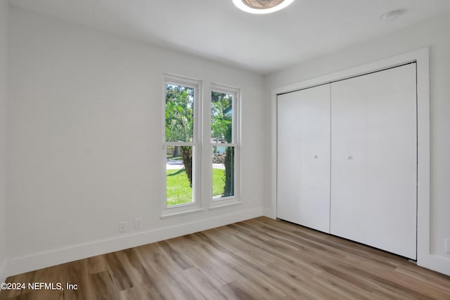 unfurnished bedroom featuring a closet and light wood-type flooring