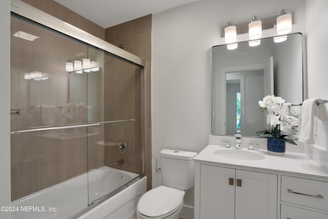 full bathroom with toilet, vanity, a textured ceiling, and enclosed tub / shower combo