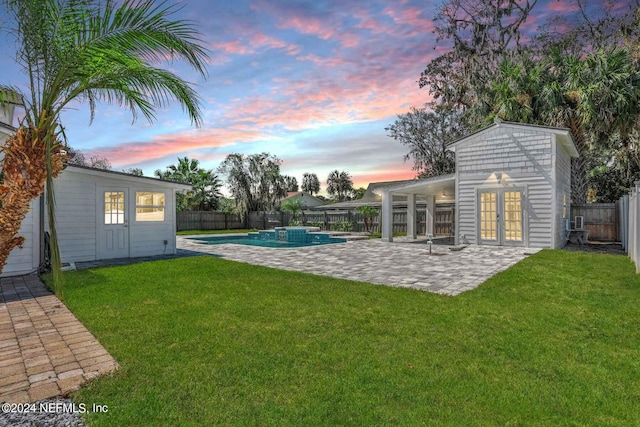 yard at dusk featuring a fenced in pool and a patio