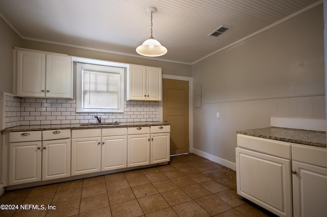 kitchen featuring ornamental molding, white cabinetry, decorative light fixtures, and sink