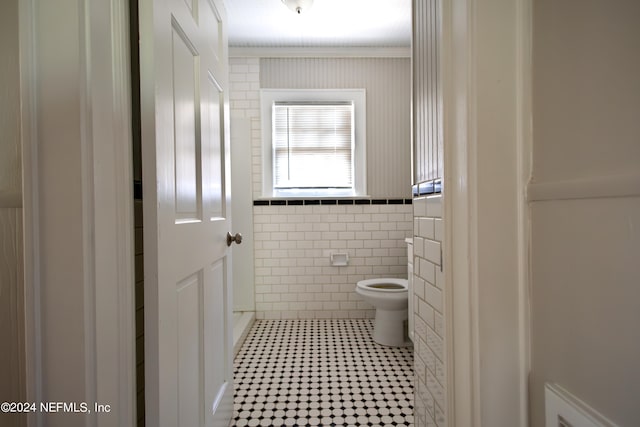 bathroom with tile walls and toilet