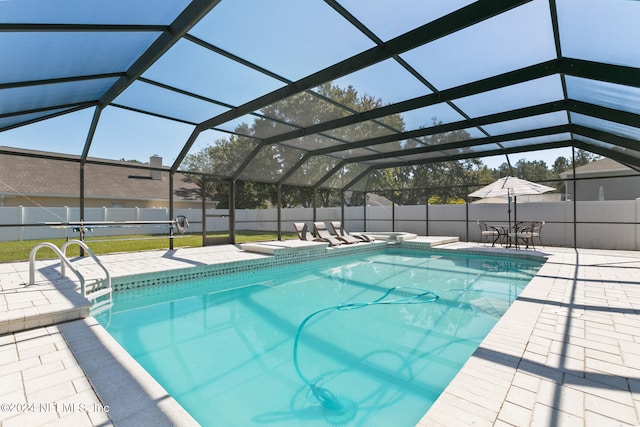 view of swimming pool with glass enclosure and a patio area