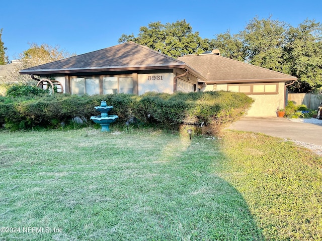 single story home featuring a front lawn