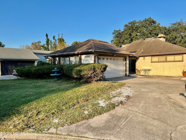 ranch-style home featuring a garage and a front lawn